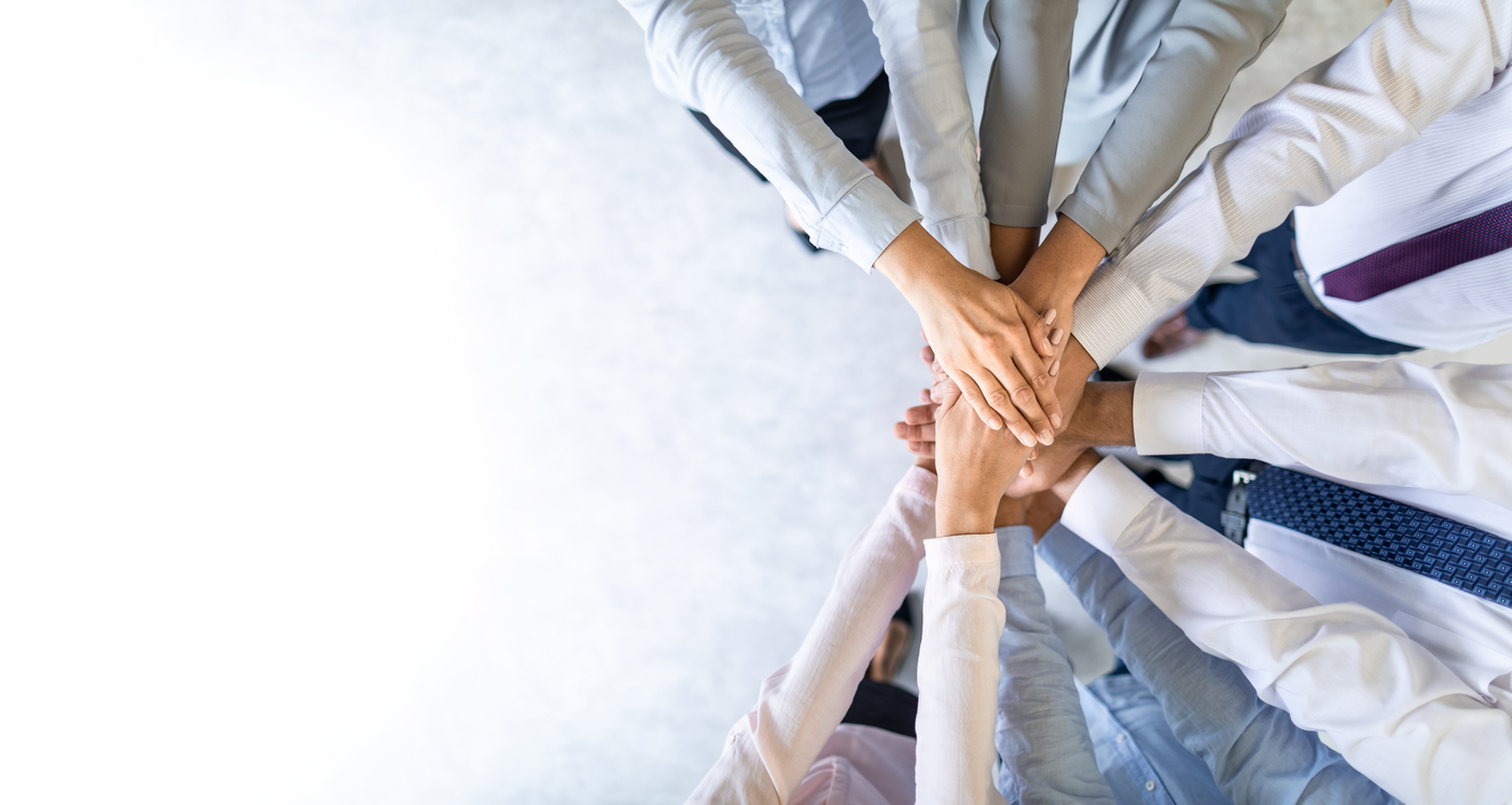 Close up top view of young business people putting their hands together. Stack of hands. Unity and teamwork concept.